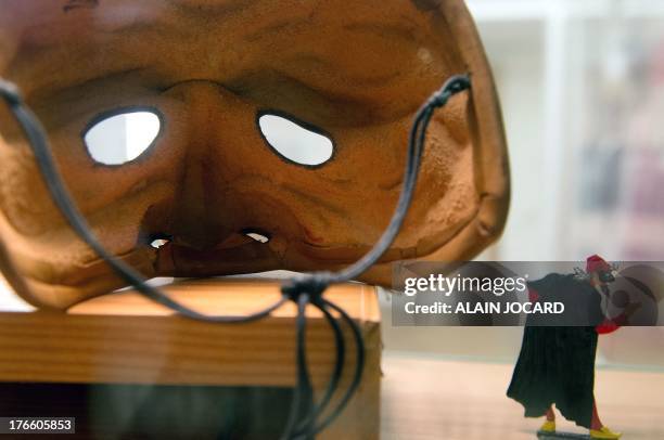 Picture taken on August 14, 2013 shows a tin figurine and a mask from the Italian "Commedia dell'arte" theater at the museum of fairground theater on...