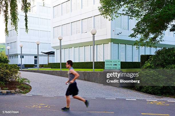 Jogger runs past the entrance to Glencore Xstrata Plc's headquarters in Baar, Switzerland, on Thursday, Aug. 15, 2013. Glencore Xstrata, the mining...