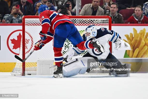 Nick Suzuki of the Montreal Canadiens scores on goaltender Laurent Brossoit of the Winnipeg Jets during the shootout at the Bell Centre on October...