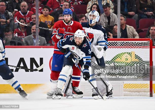 Josh Anderson of the Montreal Canadiens and Brenden Dillon of the Winnipeg Jets battle for position in front of goaltender Laurent Brossoit during...