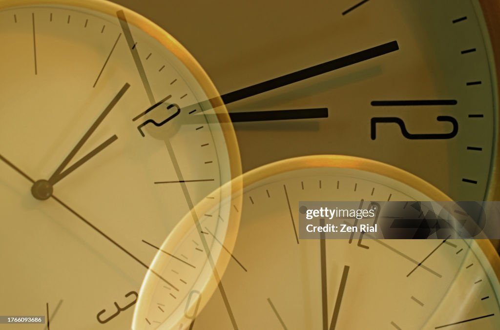 Overlapping clock faces set at 2 minutes to 12 o'clock