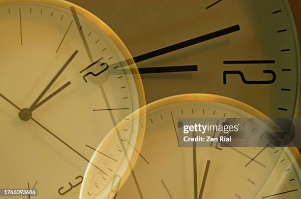 overlapping clock faces set at 2 minutes to 12 o'clock - time lapse clock stock pictures, royalty-free photos & images