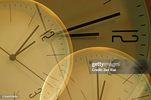 overlapping clock faces set at 2 minutes to 12 o'clock - 12 o'clock - fotografias e filmes do acervo