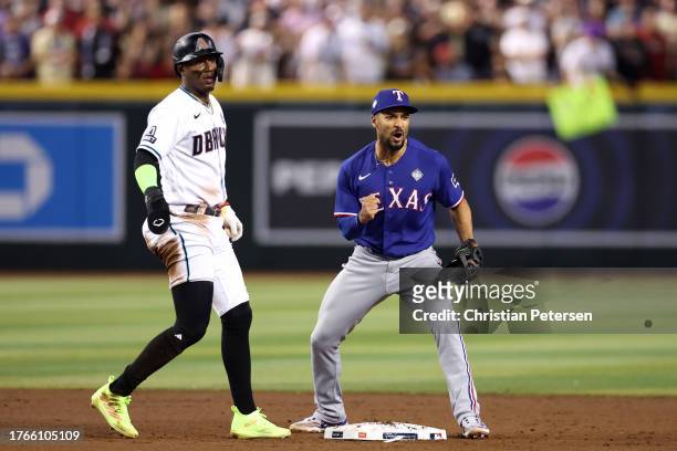 Marcus Semien of the Texas Rangers reacts after turning a double play past Geraldo Perdomo of the Arizona Diamondbacks in the eighth inning during...