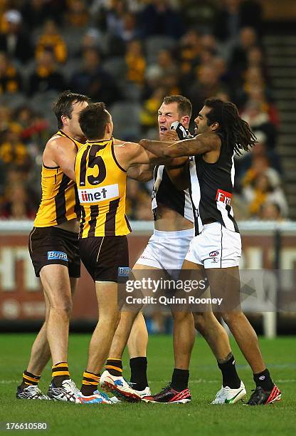 Brian Lake and Luke Hodge of the Hawks wrestle with Travis Cloke and Heritier O'Brien of the Magpies during the round 21 AFL match between the...
