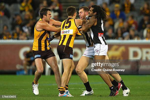 Brian Lake and Luke Hodge of the Hawks wrestle with Travis Cloke and Heritier O'Brien of the Magpies during the round 21 AFL match between the...