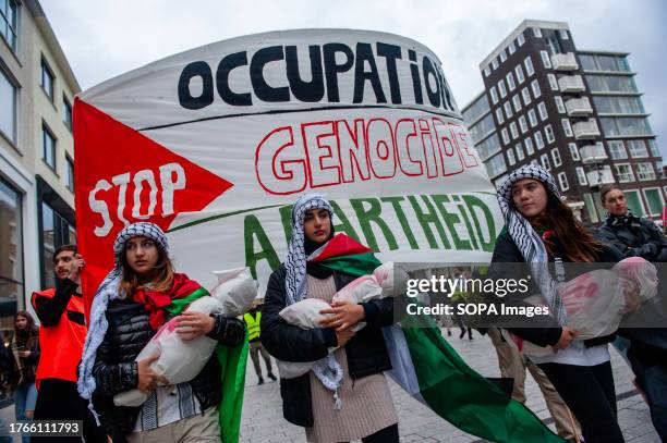 Three Palestinian women are seen holding fake dead baby bodies during the demonstration. Hundreds of people took to the streets of the city center of...