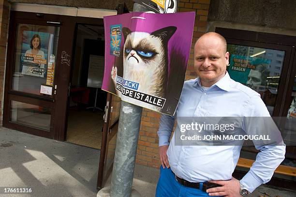 Chairman of Germany's Pirate Party Bernd Schloemer poses next to an election placard advocating the legalisation of marijuana outside the party's...