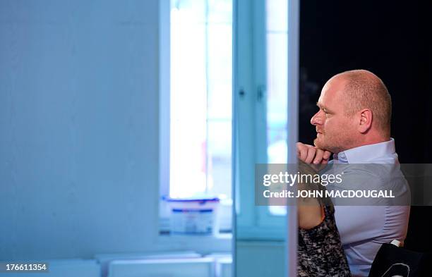 Chairman of Germany's Pirate Party Bernd Schloemer is reflected in a mirror as he addresses the party's campaign headquarters in Berlin on August 16,...
