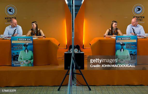 Chairman of Germany's Pirate Party Bernd Schloemer and Pirate Party candidate for Brandenburg Anke Domscheit-Berg are reflected in a mirror as they...
