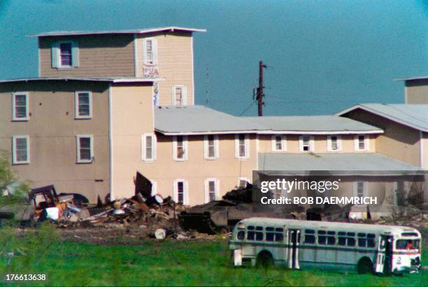 Bradley armored personnel carrier pulls a trailer containing rolls of concertina wire on April 10, 1993 past the front of the Branch Davidian...