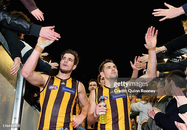 Ben Stratton and Luke Hodge of the Hawks high five fans after winning the round 21 AFL match between the Hawthorn Hawks and the Collingwood Magpies...