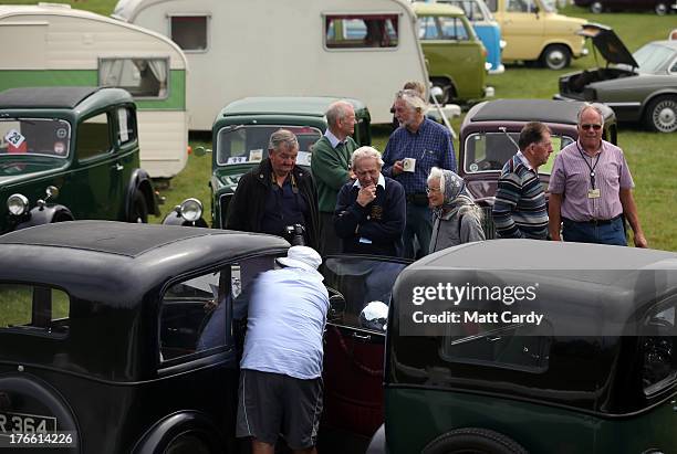 People gather around classic cars being shown in the showground at the Cornish Steam and Country Fair at the Stithians Showground on August 16, 2013...