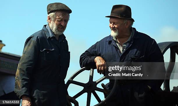 Exhibitors chat as they prepare their steam engines to show at the Cornish Steam and Country Fair at the Stithians Showground on August 16, 2013 near...
