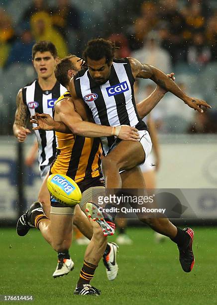 Heritier O'Brien of the Magpies kicks whilst being tackled by Brad Sewell of the Hawks during the round 21 AFL match between the Hawthorn Hawks and...