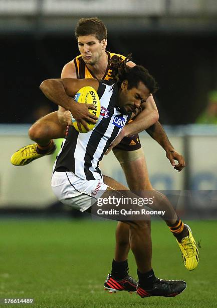 Heritier O'Brien of the Magpies is tackled by Luke Breust of the Hawks during the round 21 AFL match between the Hawthorn Hawks and the Collingwood...