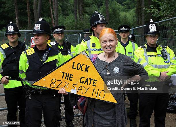 British Fashion designer Vivienne Westwood stands in front of police as she joins protesters at the anti-fracking camp on August 16, 2013 in...