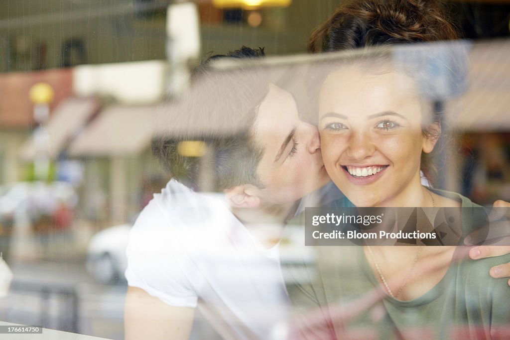 Late teens boy kissing his girlfriend on the cheek