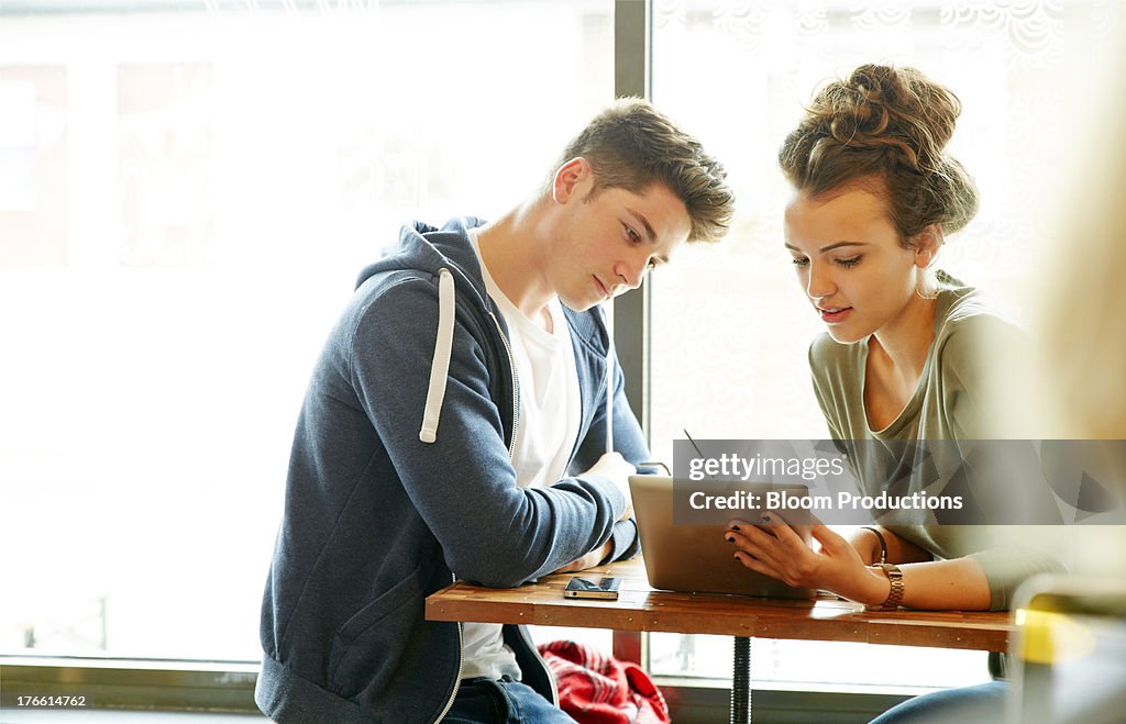 Late teens in a cafe using a tablet