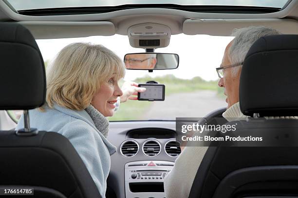 mature couple using in a car using sat nav - altes auto stock-fotos und bilder