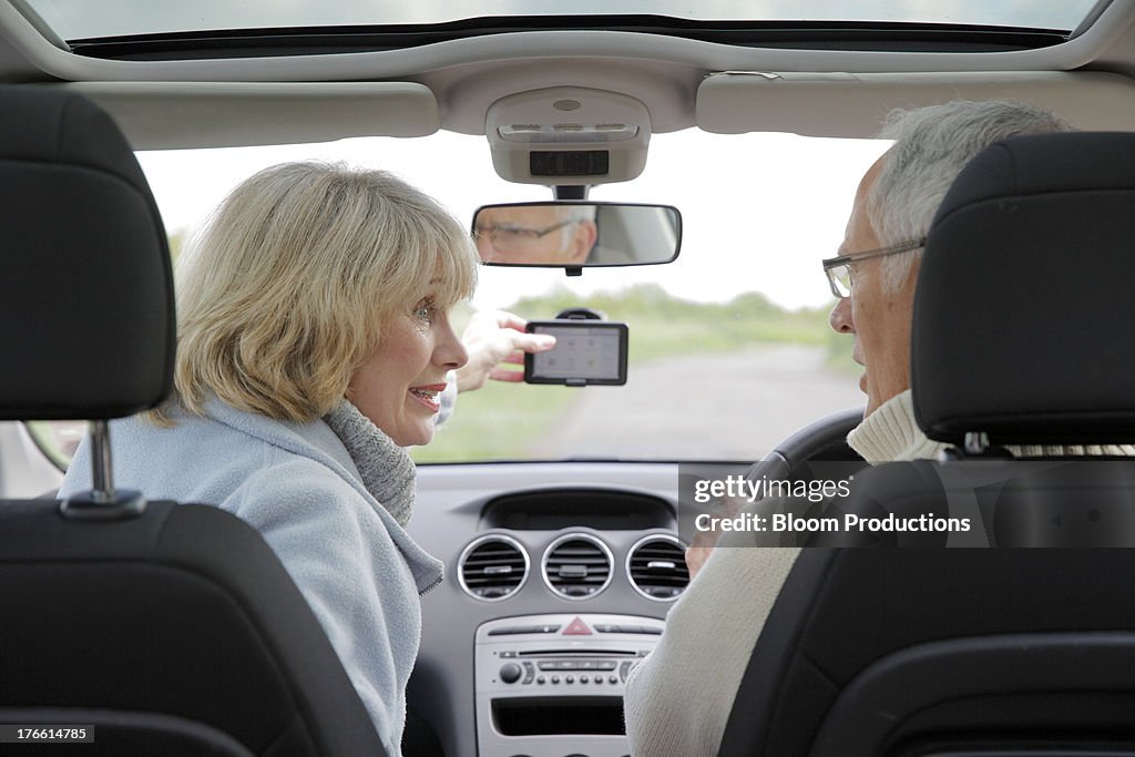 Mature couple using in a car using sat nav
