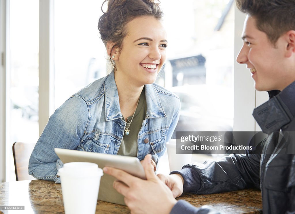 Late teens in a cafe using technology