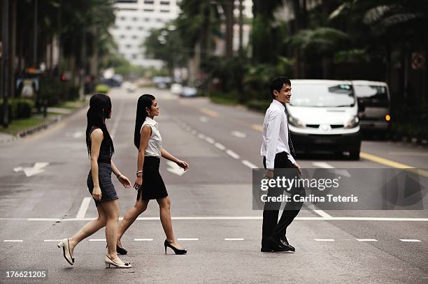 young business executives cross the street - singapore city day stock pictures, royalty-free photos & images