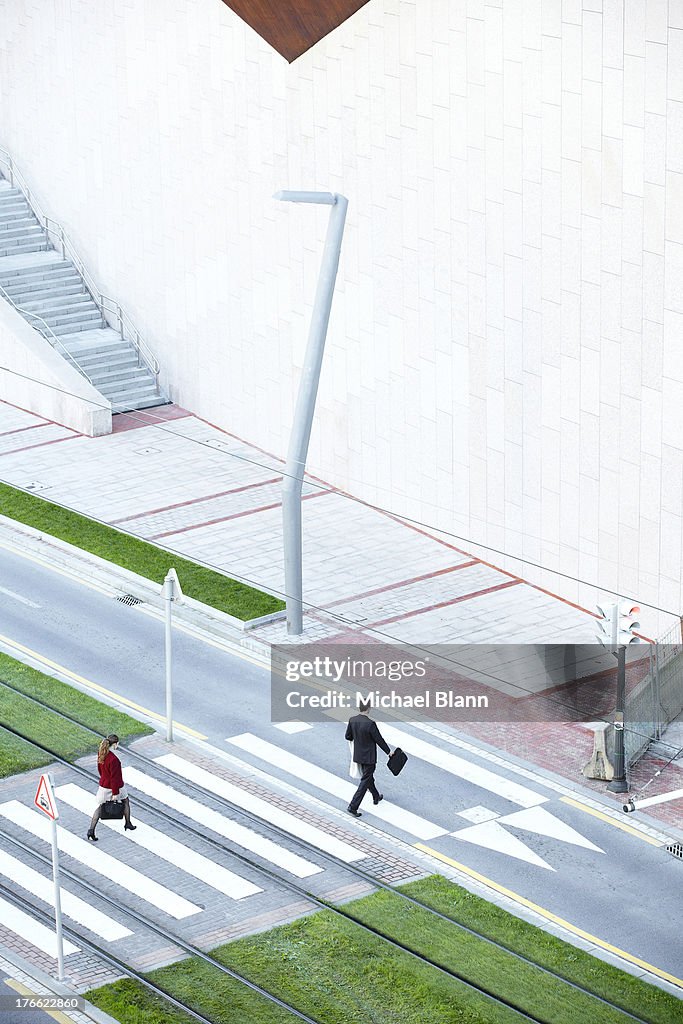 Commuters walking across zebra crossing