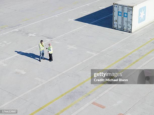 workers in shipping docks talking - dockarbeiter stock-fotos und bilder