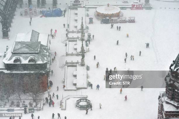 This aerial photo taken on November 6, 2023 shows people taking photos during snowfall in Harbin, in China's northeastern Heilongjiang province. /...