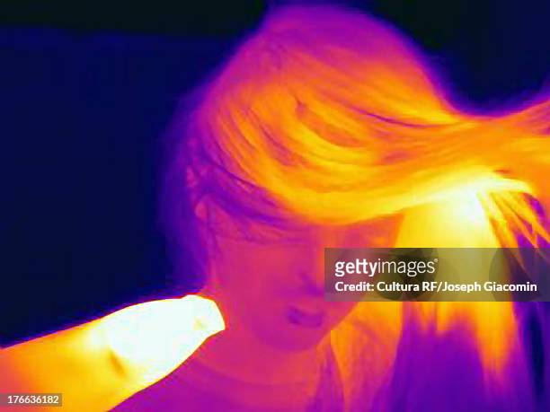 thermal image of young woman drying her hair - wärmebild stock-fotos und bilder