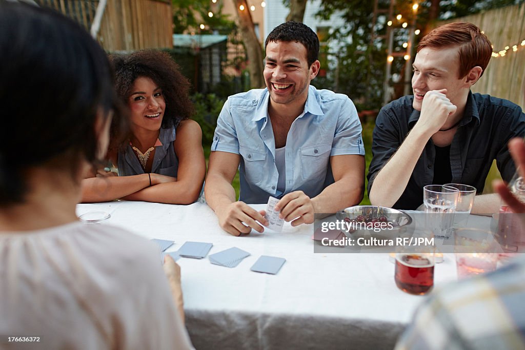 Friends playing card game at garden party