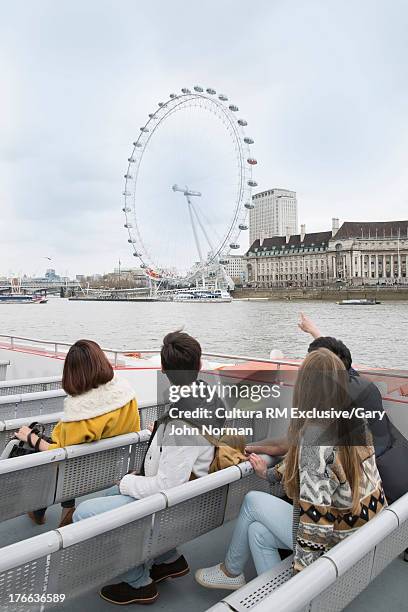 tourists on riverboat looking at london eye - millennium wheel stock pictures, royalty-free photos & images