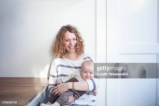 germany, bavaria, munich, mother and son, smiling, portrait - mum sitting down with baby stockfoto's en -beelden