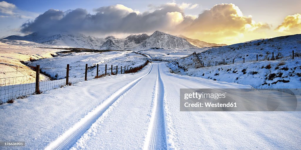 UK, Scotland, View of tyre track and snow mountains