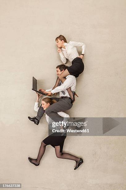 businesswoman carrying business people using laptops on shoulders - carrying a person on shoulders stock pictures, royalty-free photos & images