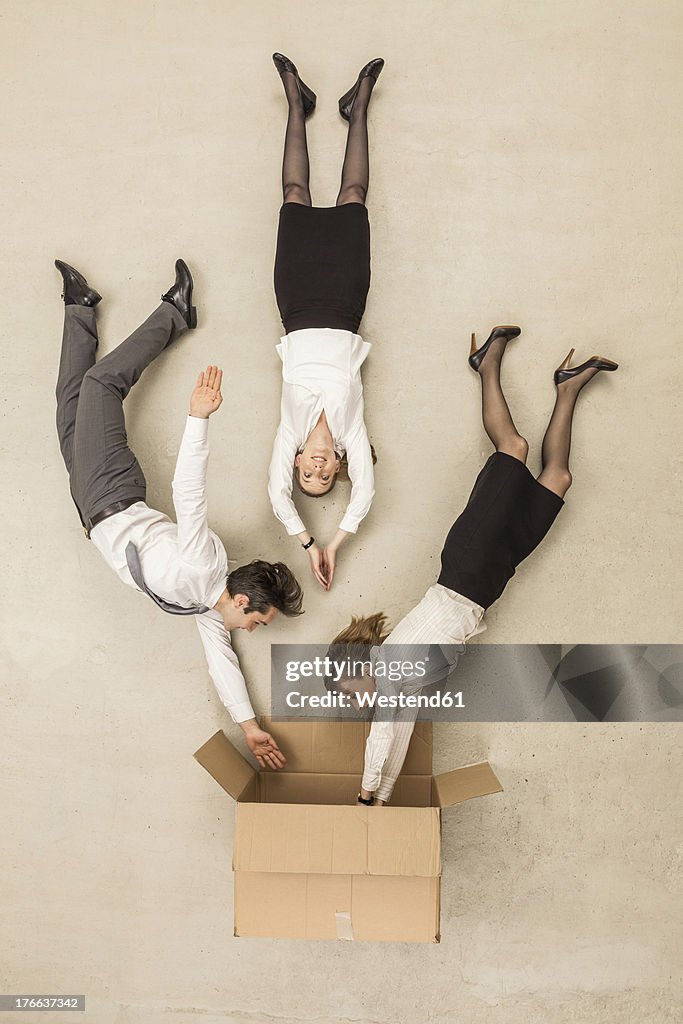 Business people getting inside box