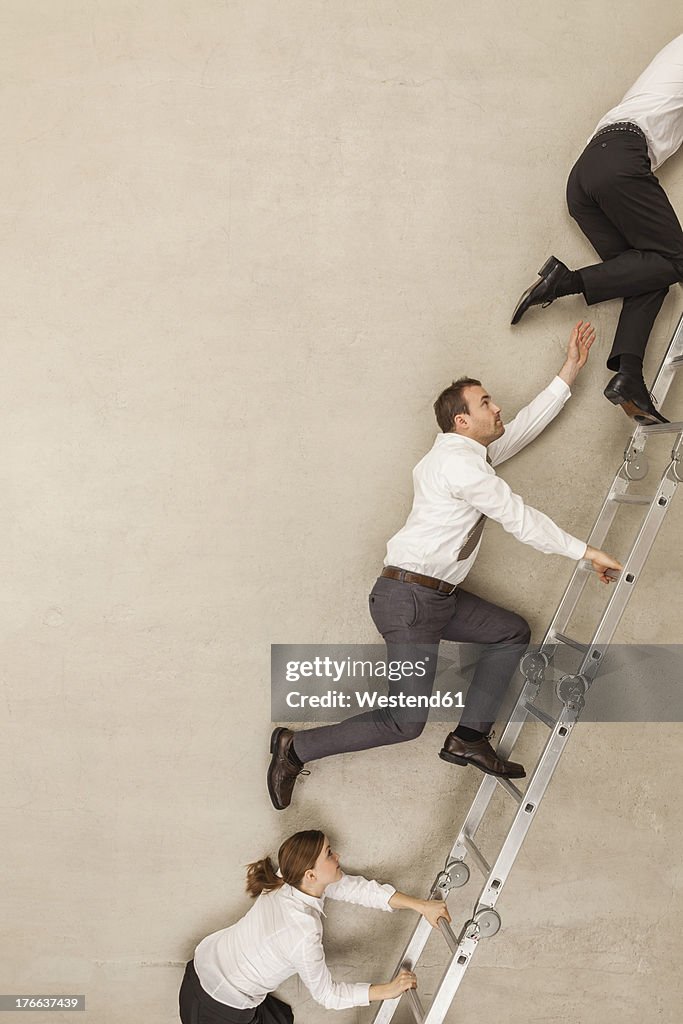 Business people climbing ladder in office