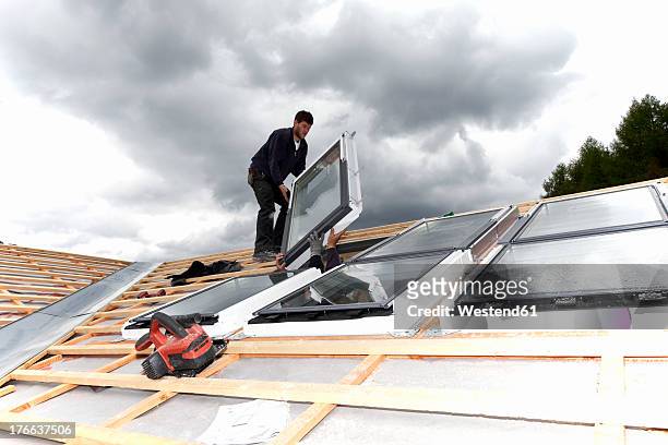 europe, germany, rhineland palatinate, workers installing roof windows - window installation stock pictures, royalty-free photos & images