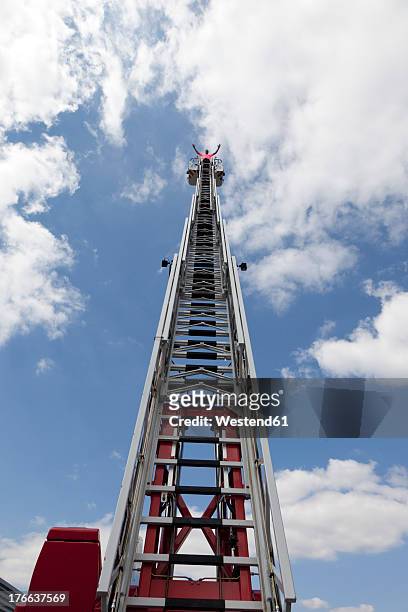 europe, germany, rhineland-palatinate, man standing on top of fire engine ladder - feuerwehr deutschland stock-fotos und bilder
