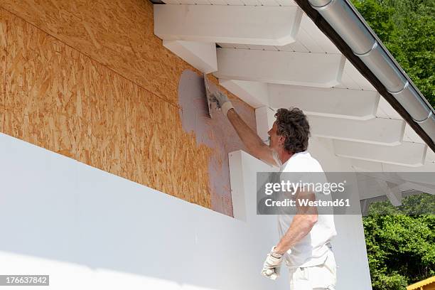 europe, germany, rhineland palatinate, man insulating polystyrene - isolation stock-fotos und bilder