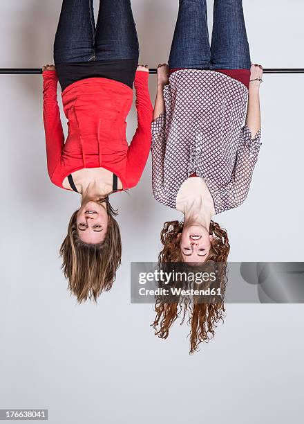 young women hanging upside down, smiling - upside down ストックフォトと画像