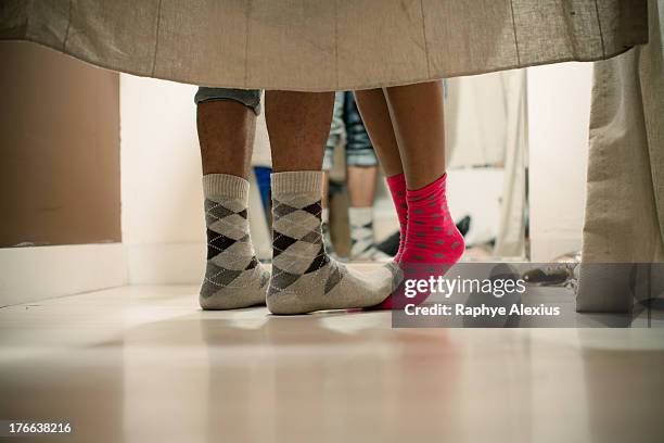 young couple wearing socks in changing room, low section - omklädningsrum bildbanksfoton och bilder