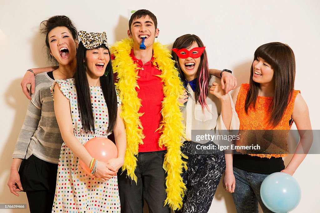 Friends at a party with balloons, studio shot