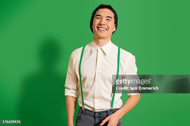 portrait of young man wearing green braces - hosenträger stock-fotos und bilder
