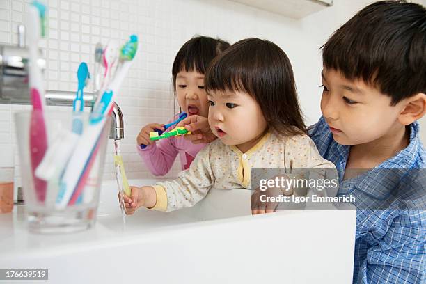 brother helping sisters to clean teeth - toothbrush ストックフォトと画像