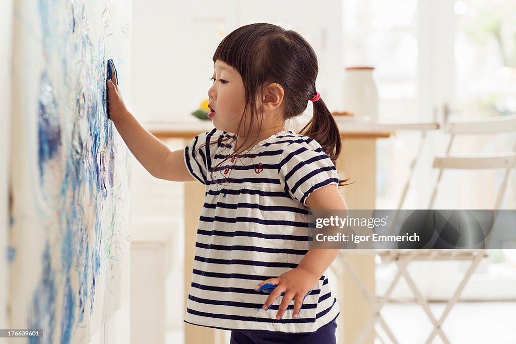 Female toddler making handprint painting