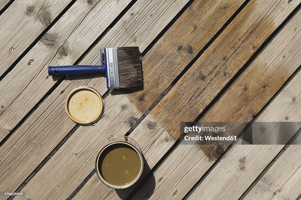 Germany, Cologne, Wood panel with wood stain and paint brush