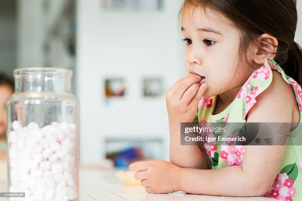 Close up of young girl tasting marshmallows