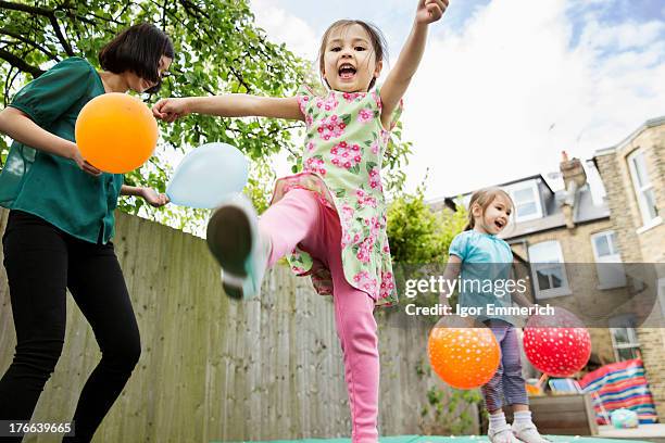 mother and daughters playing in garden with balloons - toddler girl dress stockfoto's en -beelden